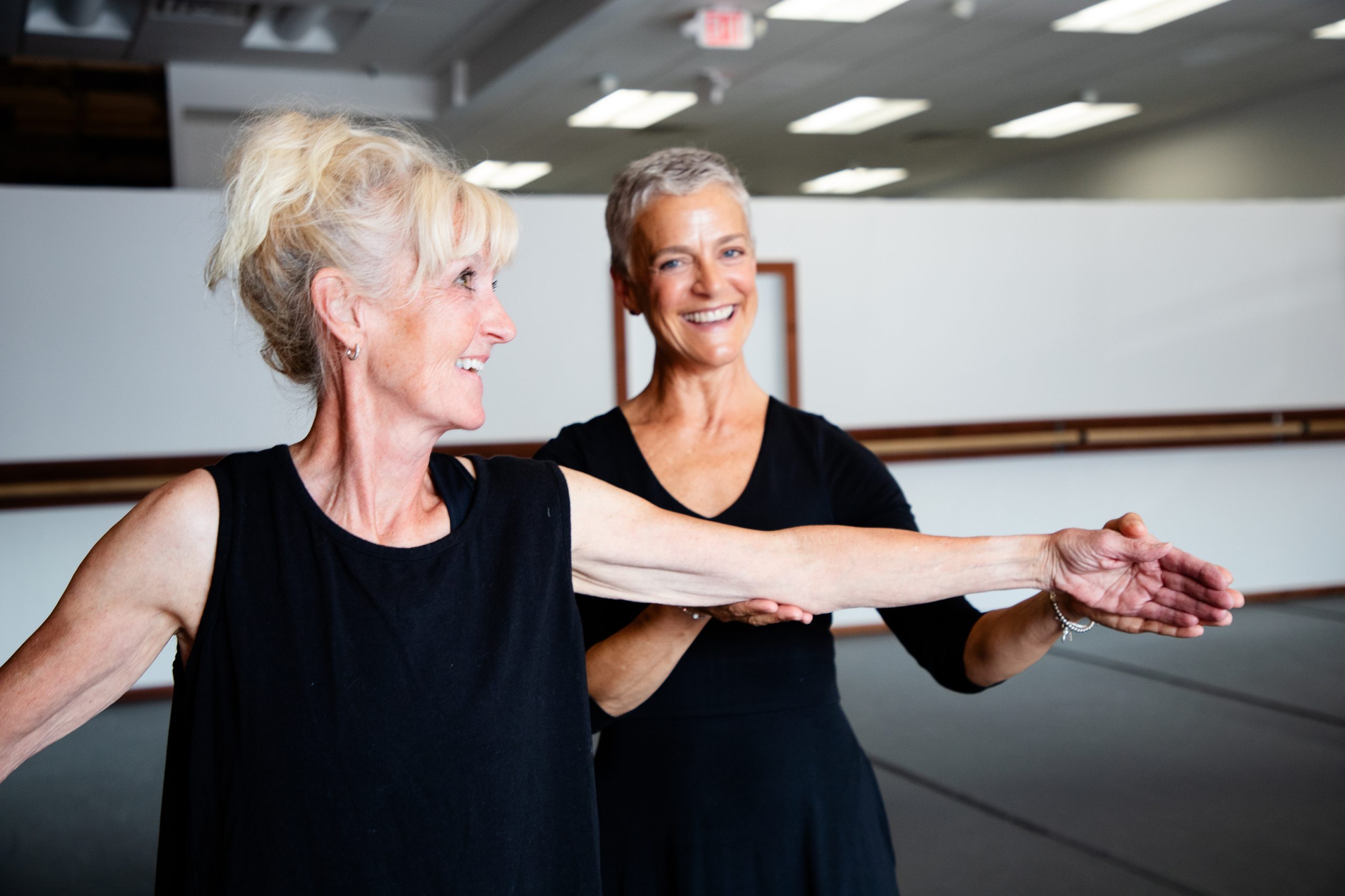 older ballet dancer lead into pose by older ballet instructor during Silver Swans RAD class